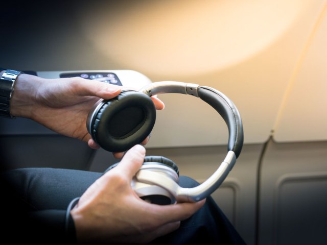 Close-up view of airplane passenger holding headphones