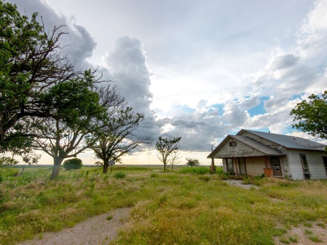 Home on field in Oklahoma under cloudy skies