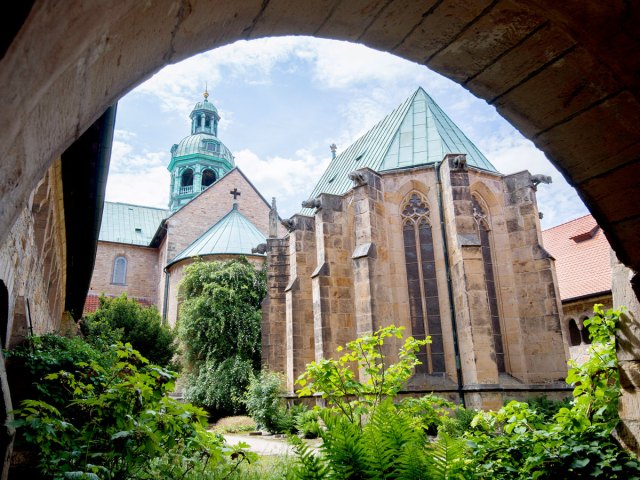 Rose bushes seen through stone arch at Hildesheim Cathedral in Germany
