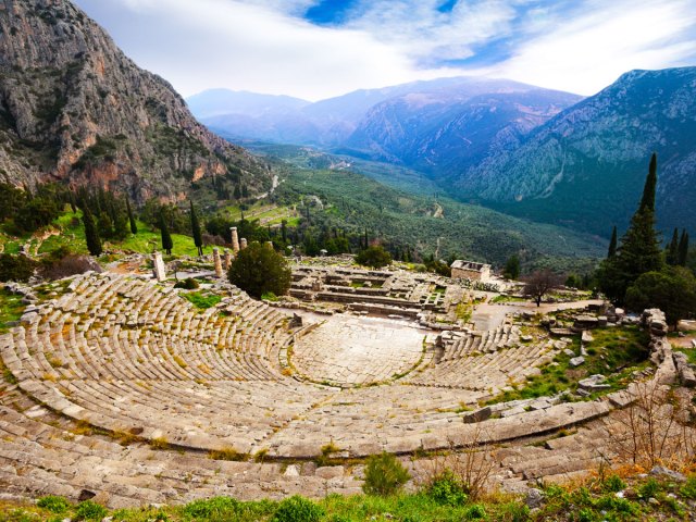Overview of ruins of Theater of Delphi in Greece with mountains in background