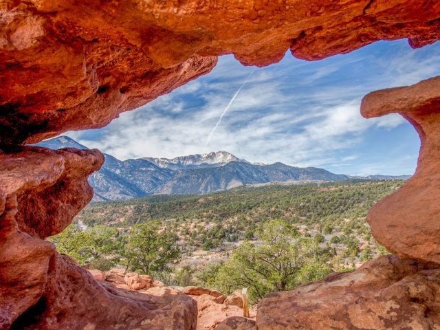 View of Pikes Peak in Colorado through natural stone arch
