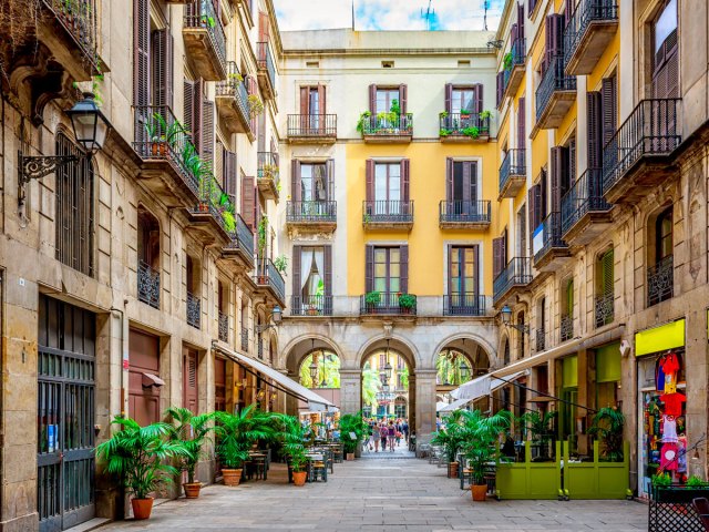 Narrow street lined with cafes and apartments above in Barcelona, Spain