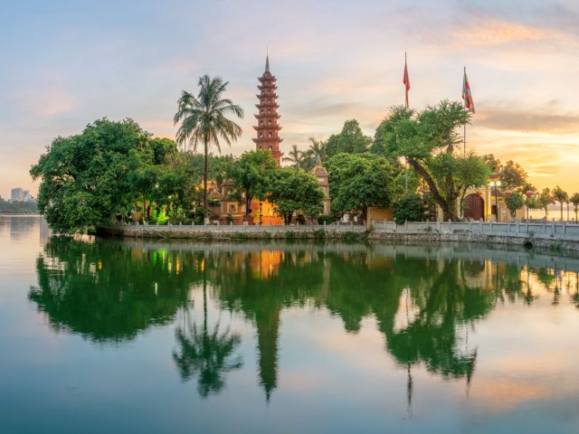 Temple and trees reflecting on water in Vietnam