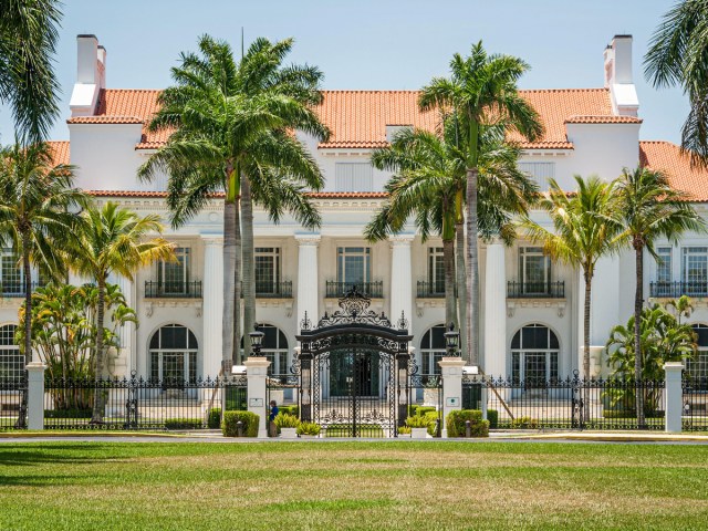 Whitehall Mansion seen beyond iron gate flanked by palm trees, in Palm Beach, Florida