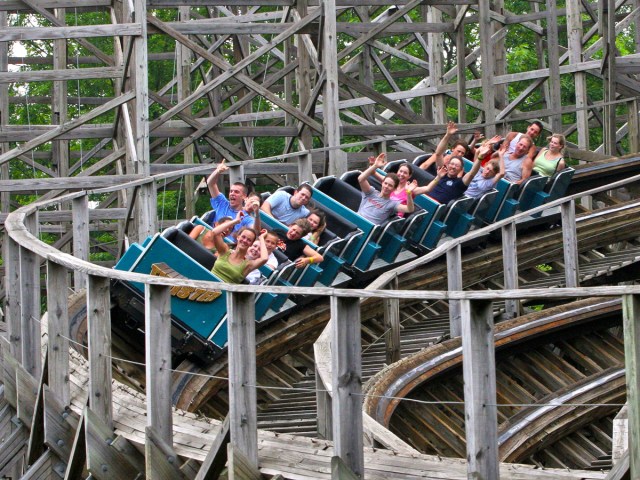 Riders on wooden roller coaster
