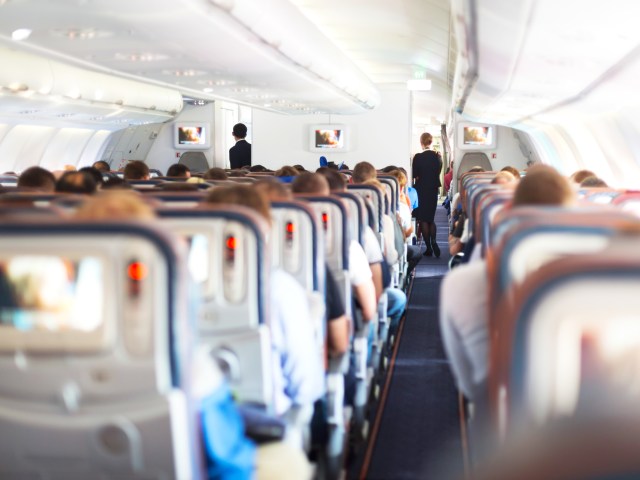 View of economy class airplane cabin from rear