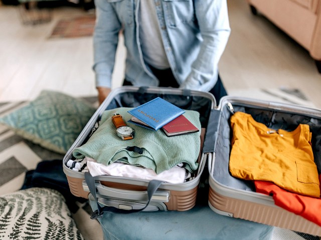 Close-up image of person packing suitcase
