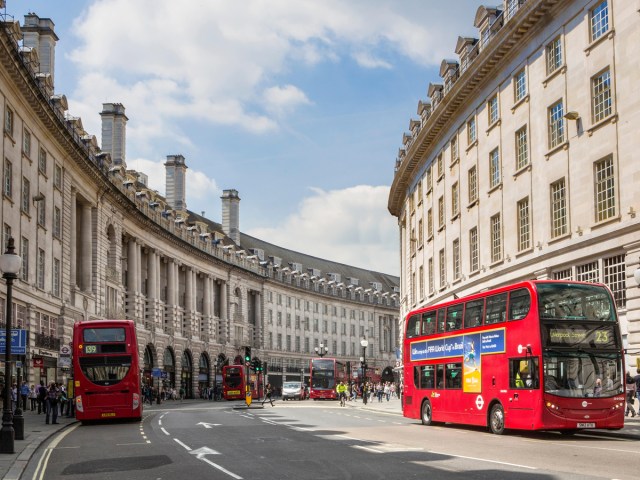 Red double-decker buses on curving street in London, England