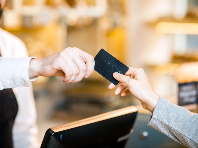 Close-up view of customer handing over credit card to pay