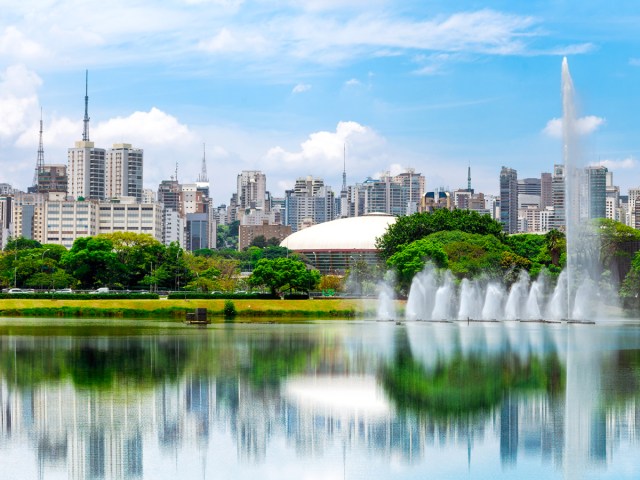 Fountain and lake with skyscrapers in background in Ibirapuera Park in Sao Paulo, Brazil