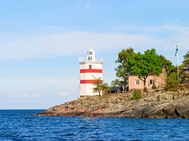 Red and white striped lighthouse on coast of Sweden's Lake Vänern