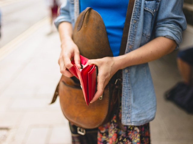 Close-up of person reaching into red wallet