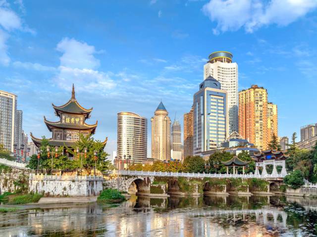 Traditional temple and modern skyscrapers, seen from across river in  Guiyang, China