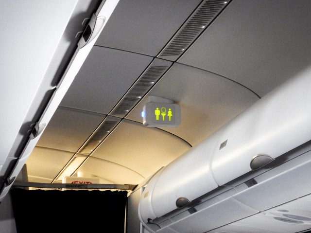 Zoomed-in image of lavatory sign in airplane cabin