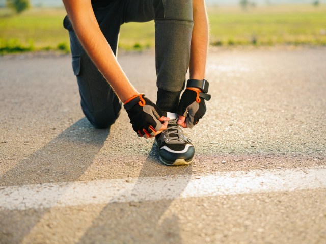 Close-up image of runner tying shoes