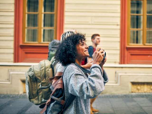 Traveler with group holding up camera to take photo