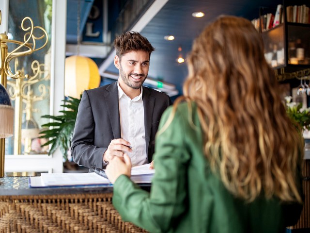 Hotel front desk associate speaking to customer