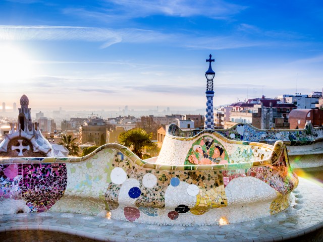 Colorful mosaic tiled wall overlooking Barcelona skyline at Parc Guell