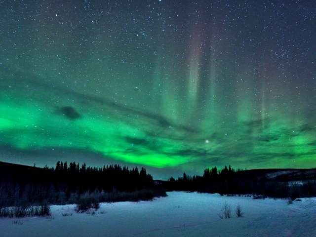 Greenish hues of the northern lights in night sky over Fairbanks, Alaska