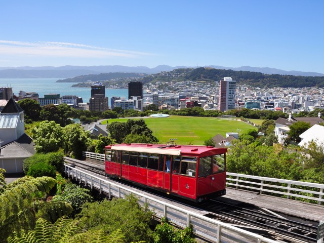 Red cable car ascending mountain overlooking Wellington, New Zealand