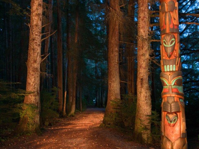 Totem poles along forest trail in Sitka, Alaska