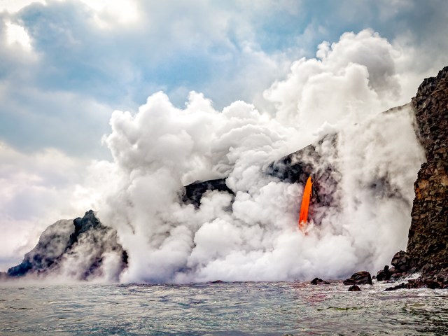 Lava flowing off cliff into sea at Hawaii Volcanoes National Park