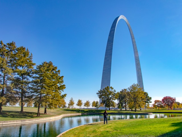 Person standing in park in front of Gateway Arch in St. Louis, Missouri