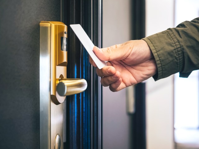 Zoomed-in image of traveler using key card to open hotel room door