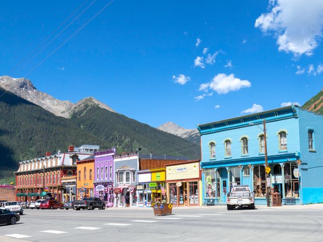 Brightly painted storefronts surrounded by mountains in Durango, Colorado
