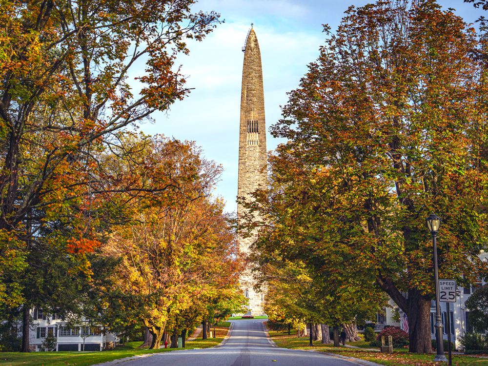 Bennington Battle Monument in Vermont at end of road framed with fall foliage