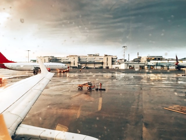 View through airplane window of rainy airport tarmac