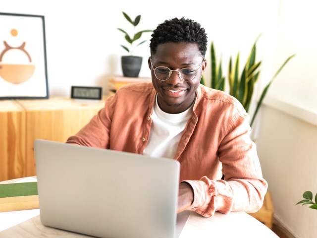 Person sitting at table working on laptop