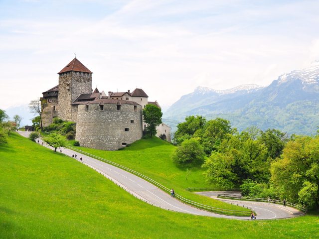 Castle on sloping green hillside in Vaduz, Liechtenstein 