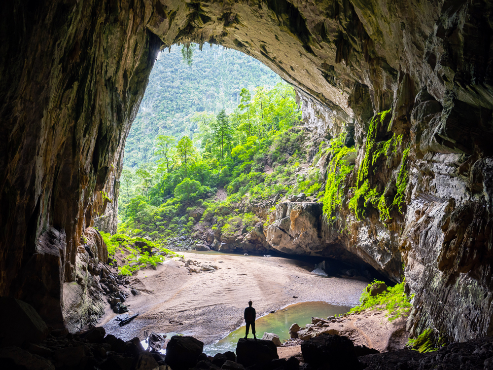 Silhouette of person standing at entrance to Hang Sơn Đoòng cave in Vietnam