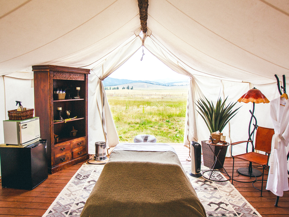 Glamping accommodations overlooking grassy field and hills at Resort at Paws Up in Montana