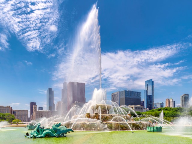 Water from Buckingham Fountain shooting high into the air with Chicago skyline in background