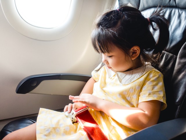 Young child seated in airplane seat