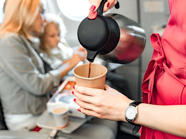 Zoomed-in image of flight attendant pouring coffee on airplane