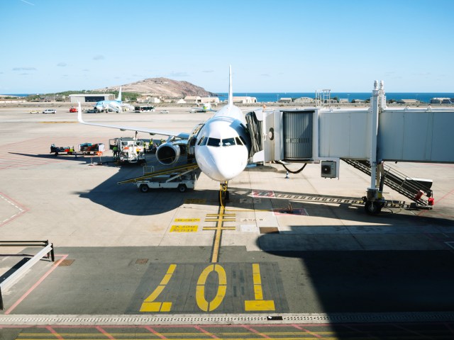 Aircraft parked at boarding gate, seen from airport terminal