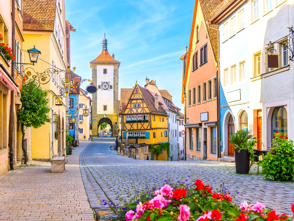Flowers and colorful buildings lining cobblestone street in Rothenburg ob der Tauber, Bavaria, Germany