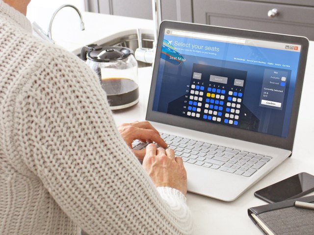 Person using laptop to select seats on flight booking