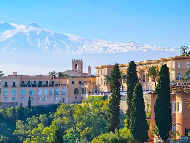 Overview of the San Domenico Palace Hotel in Sicily, Italy, with mountains in background