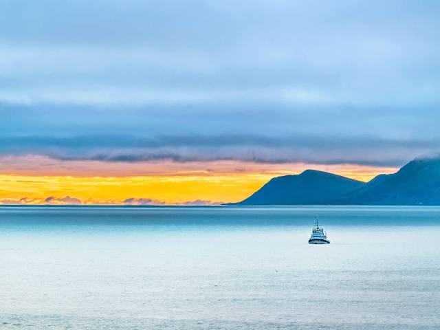 Boat in waters off Alaska's St. Lawrence Island at sunset