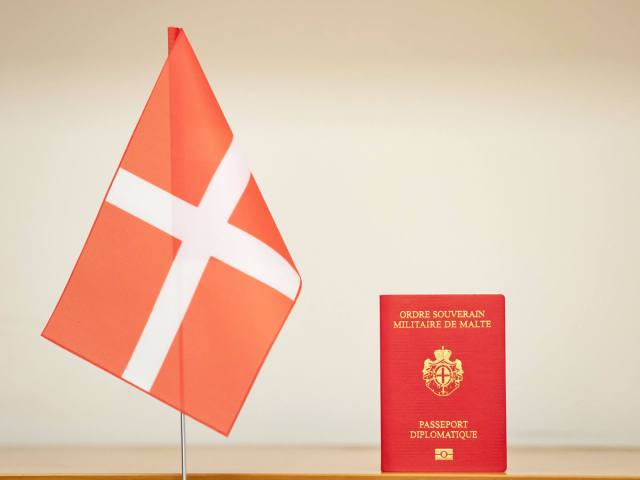 Passport of the Knights of Malta seen next to the order's flag