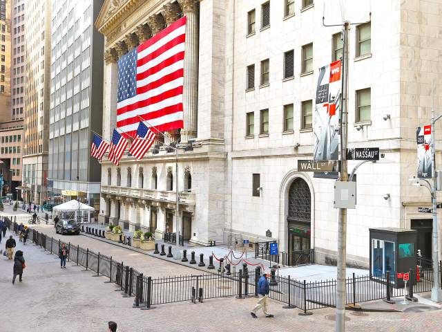 Large American flag hanging over the New York Stock Exchange on Wall Street