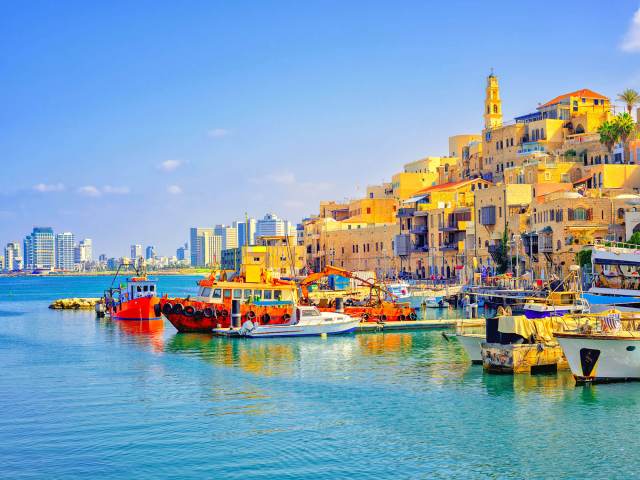 Colorful buildings in Jaffa port and Tel Aviv, Israel, skyline in background