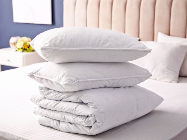 Stack of pillows and duvet cover on hotel bed