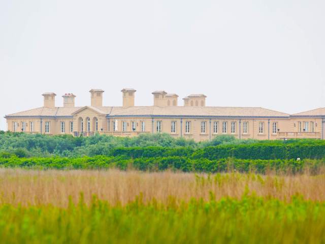 Fair Field Mansion in the Hamptons, New York, seen beyond foliage