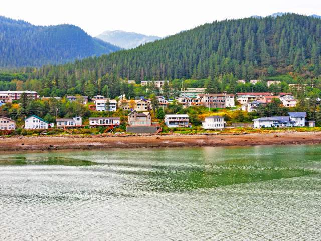 Waterfront homes with forested mountains in background in Juneau, Alaska, seen from above