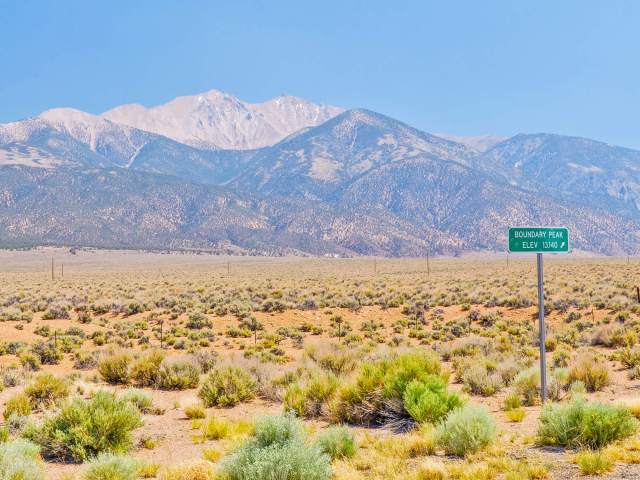 Sign indicating elevation of Boundary Peak with desert and mountains in Nevada